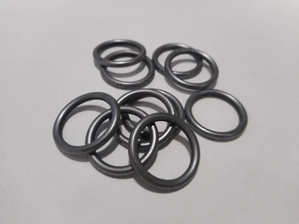 Zahlreiche schwarze O-Ringe liegen verstreut auf einer hellen Oberfläche. Diese O-Ringe sind für Anwendungen von Remeha konzipiert.